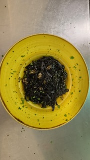 Foto originale della pasta nera nel piatto giallo